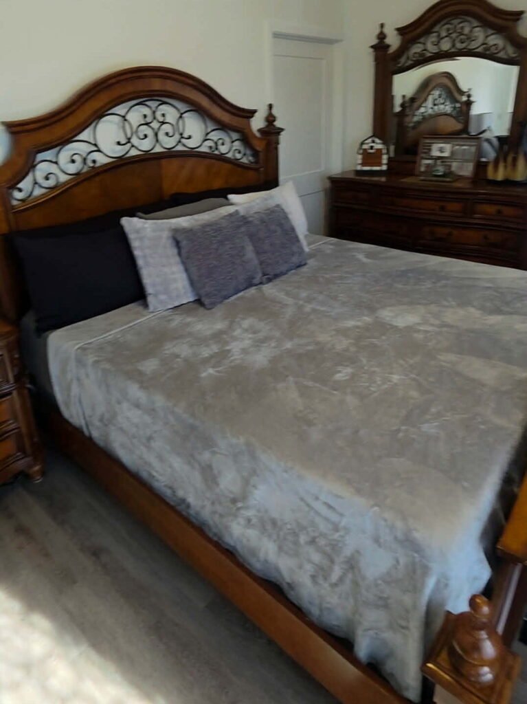 A freshly cleaned master bedroom with a meticulously made bed by THE VERSATILE SMITHS LLC.